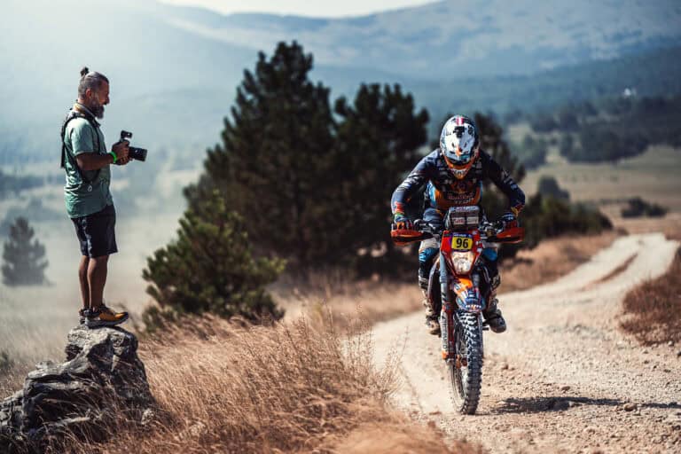 Photographer watching a rider climb a rocky trail