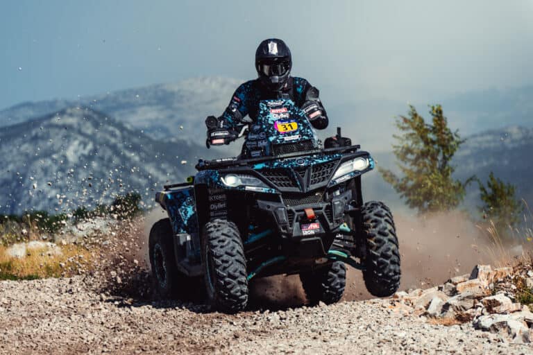 Quad rider in front of mountain ridges