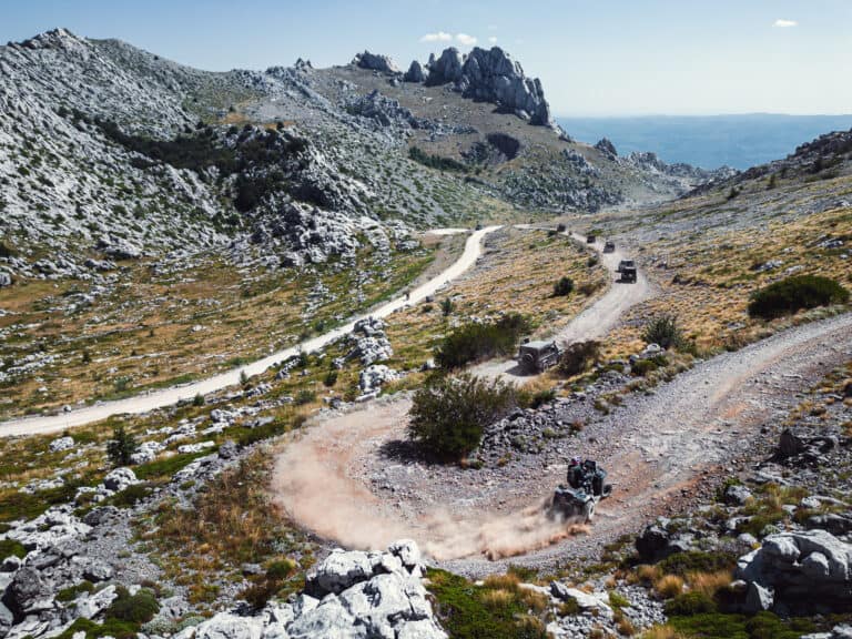 Aerial view of a gravel track through a karst valley