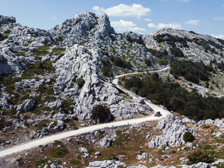 Gravel road winding through white limestone rocks