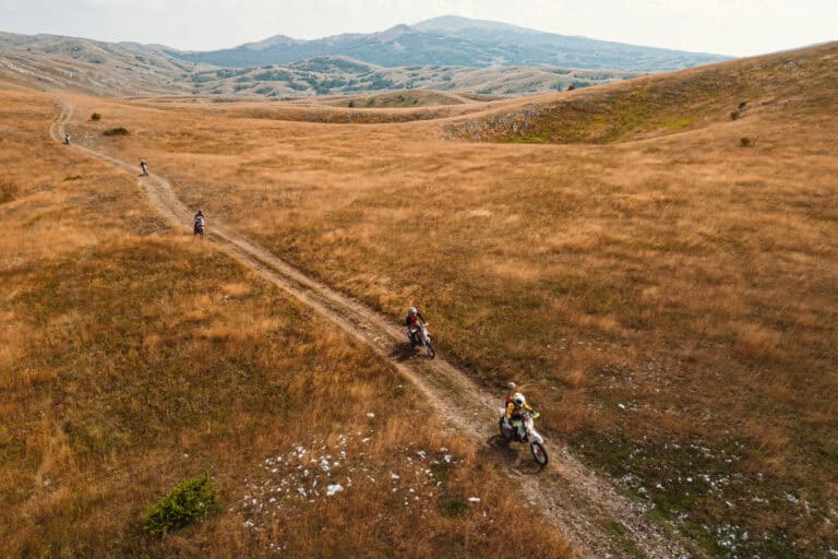 Rider crossing a golden grassy plateau