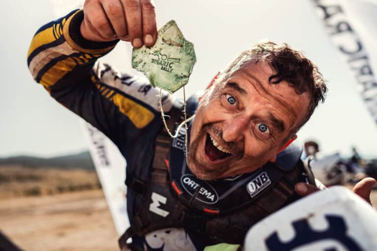 Rider holding up his stone finisher medal