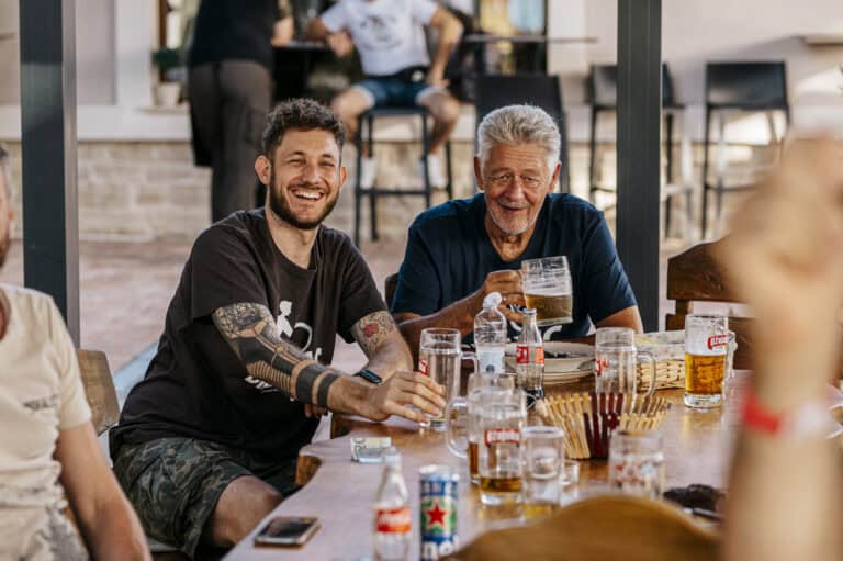 Riders sharing drinks at a table after the stage