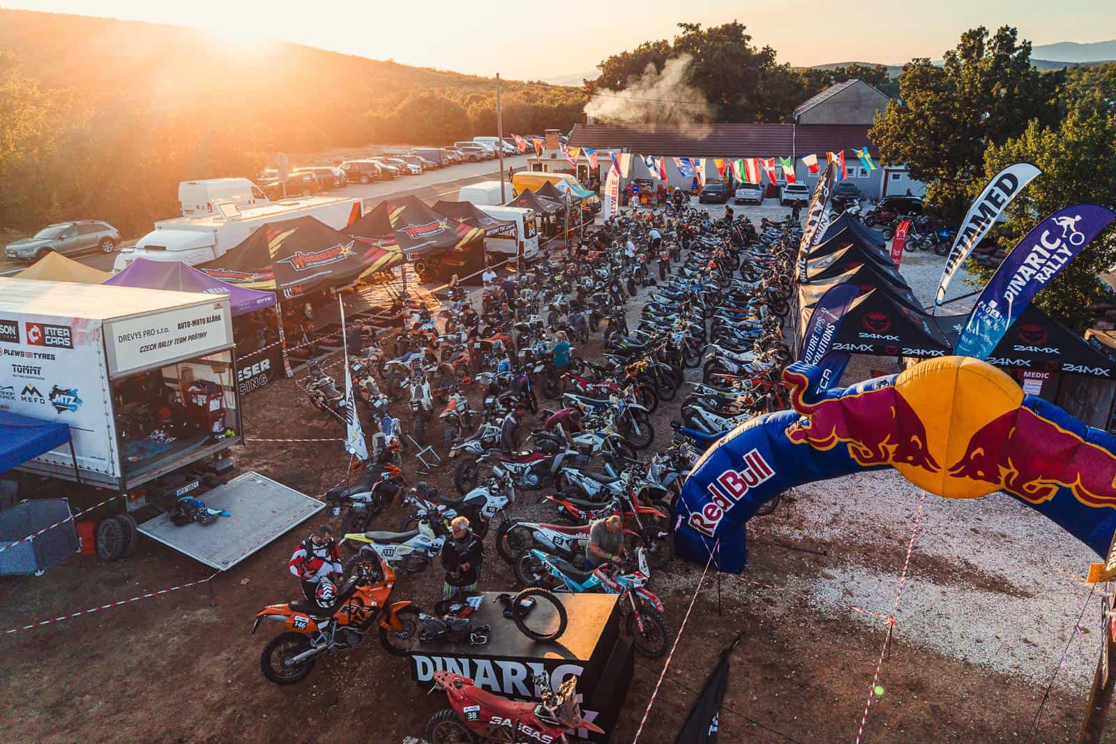 Bivacco del Dinaric Rally con le moto al tramonto, veduta aerea