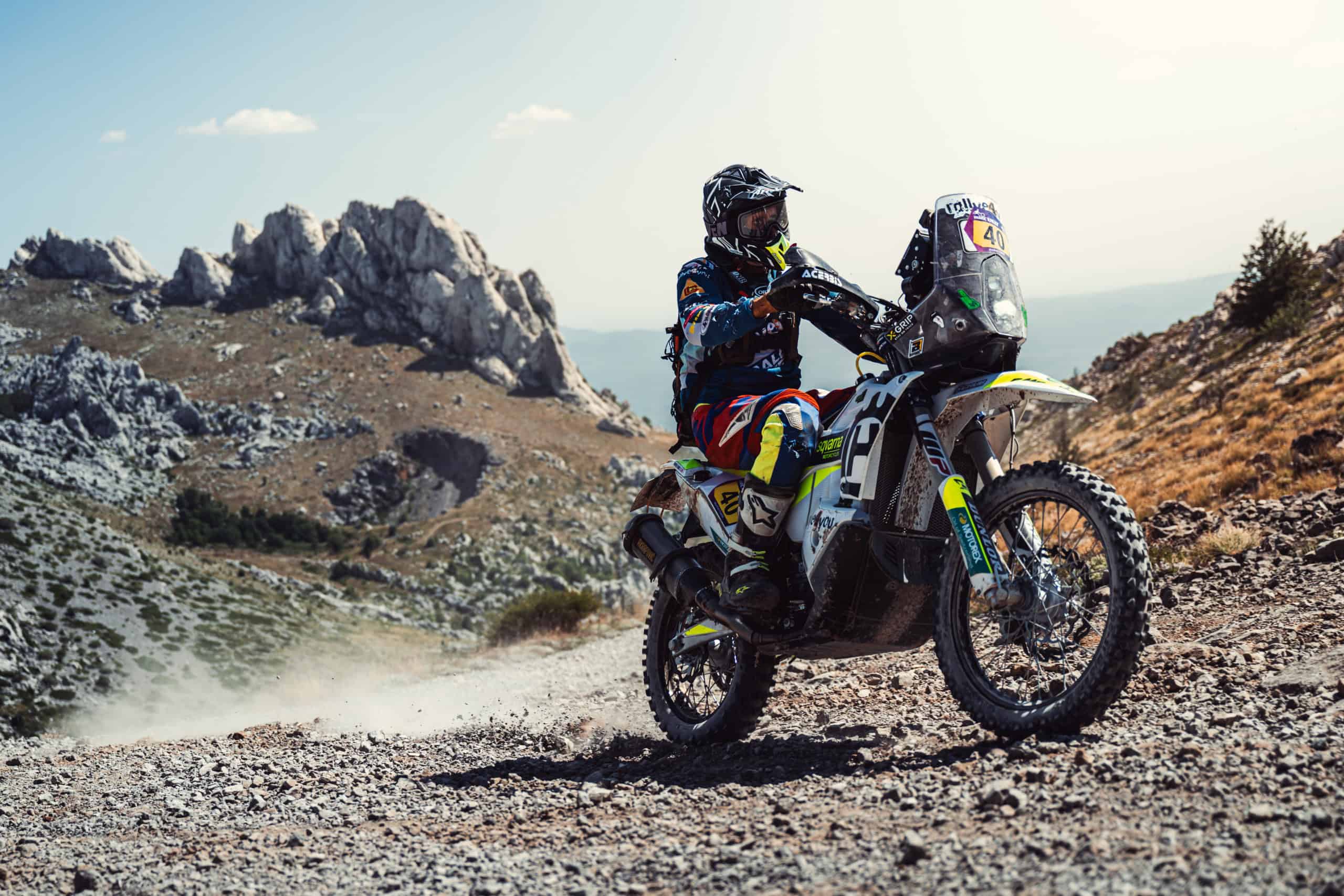 Pilota di rally su una pista rocciosa sotto torri di calcare