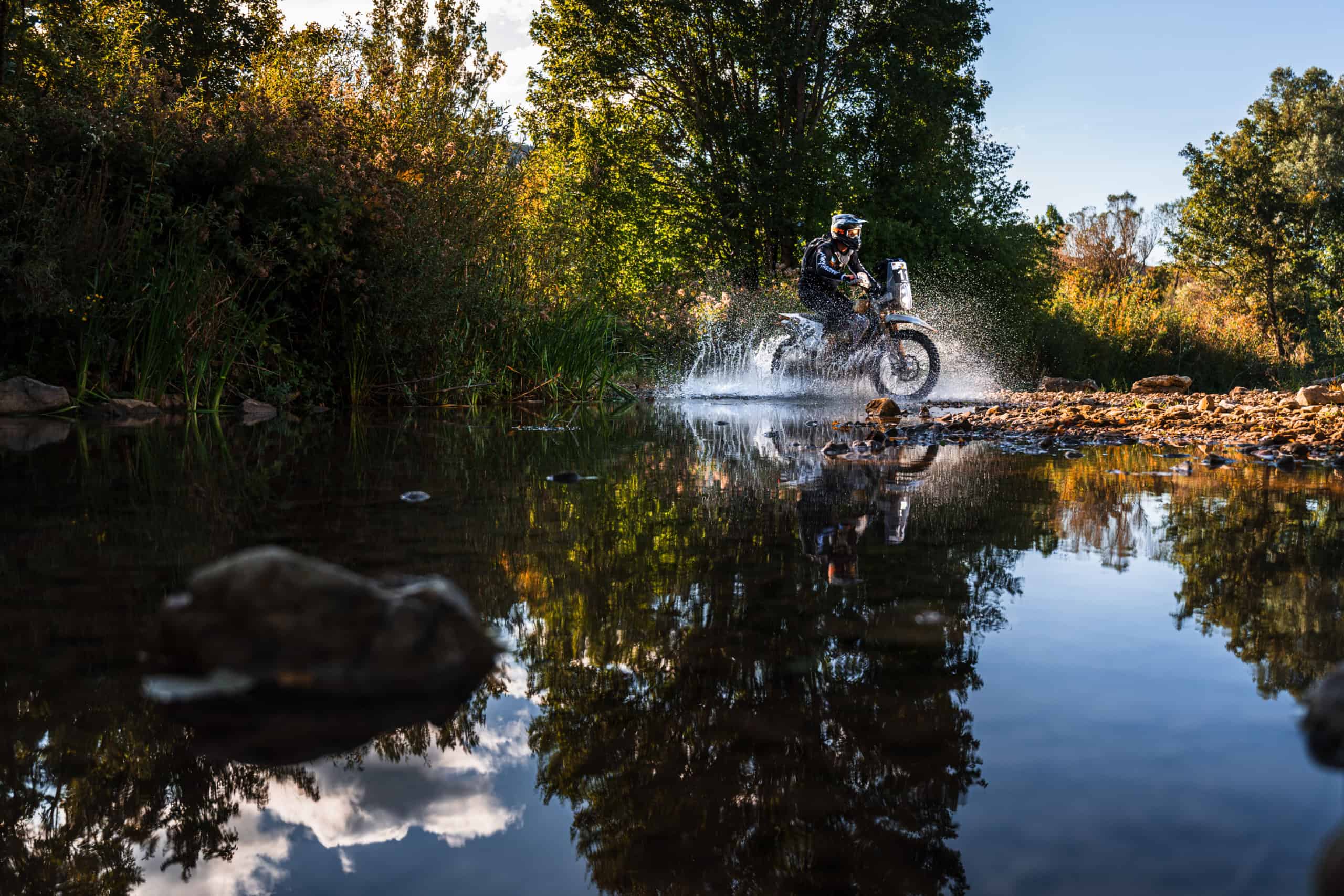Rally rider crossing a river in the Dinaric mountains