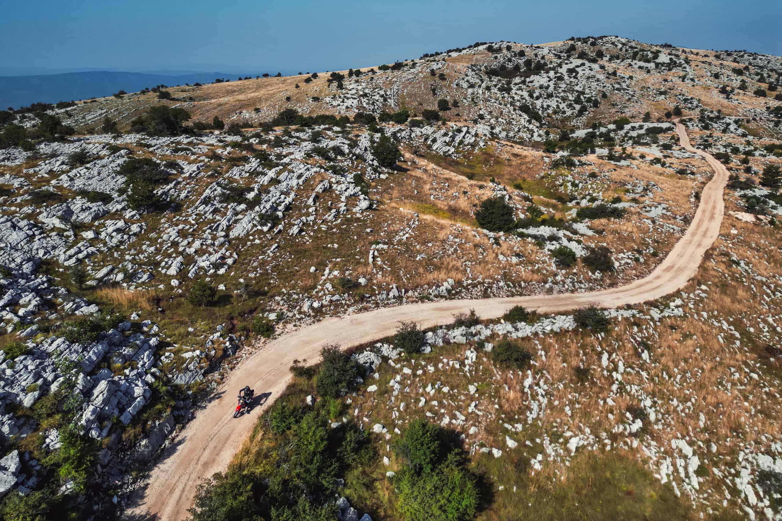Veduta aerea di una strada sterrata su un altopiano carsico roccioso